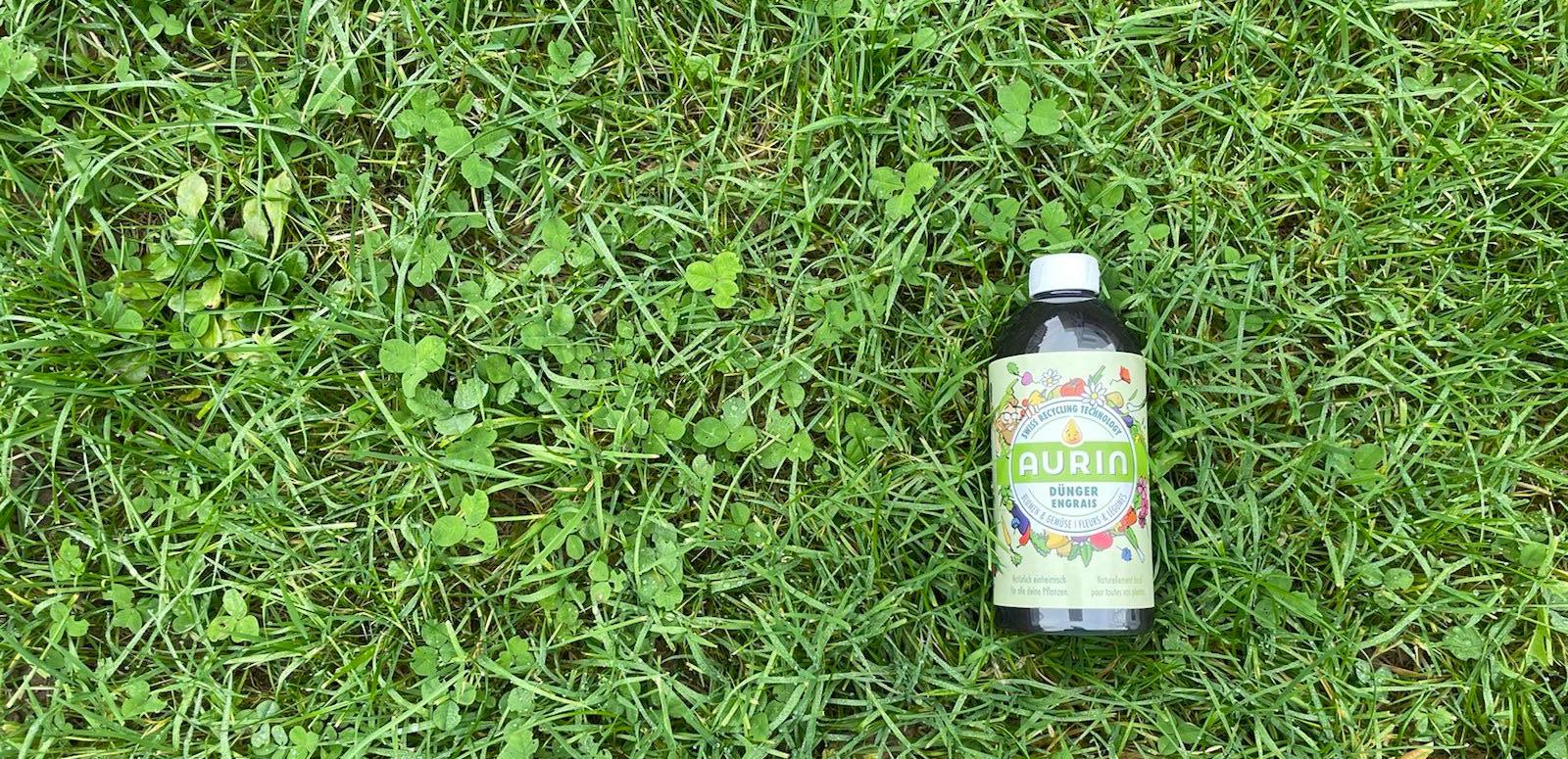 A bottle of Aurin fertiliser lying on a lawn